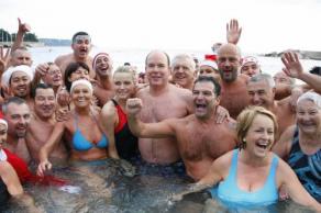 摩纳哥阿尔贝二世亲王（中）週日（12月20日）在摩纳哥公园参加了地中海游泳活动后，拥著南非泳將女友维特斯托克，与其他泳將合照。这项活动是圣诞活动之一，主要为2004年海啸的儿童受害者筹款。（图：法新社）