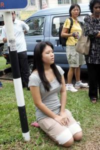 A Chinese church member at the site, sadly kneels and prays (by Sin Chiew Daily)