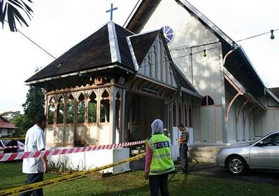 Police officers inspect damage at the All Saints Church in Taiping of Perak state, Malaysia, Sunday, Jan. 10, 2010. Another church was hit by a firebomb early Sunday, the fifth assault in three days of unrest following a court decision that allows Christians and other non-Muslims to use 'Allah' to refer to God.