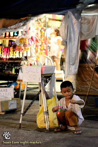 A cute Thai kid was playing with the flying toy he was sellling