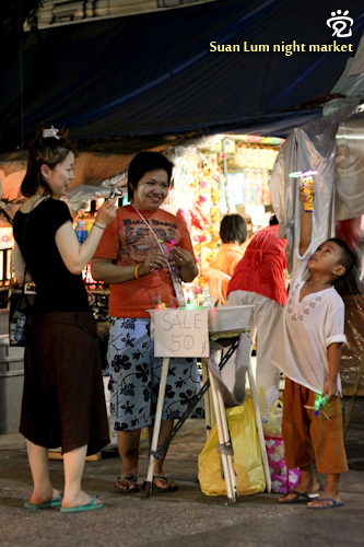 A Japanese tourist was taking photo of the cute kid playing at the Suan Lum night market