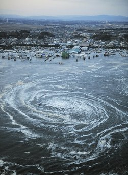 Tsunami waves swirl near a port in Oarai, Ibaraki Prefecture (state) after Japan was struck by a strong earthquake off its northeastern coast Friday, March 11, 2011. (AP Photo/Kyodo News) 