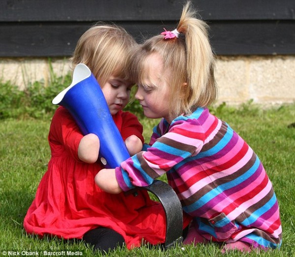 Here's how to do it: Ellie (right) shows off her new prosthetic leg to Charlotte, who hopes to get her first pair in a few months