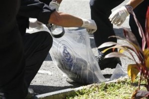 Forensic police place a pig's head into a plastic bag at a mosque in Kuala Lumpur, Malaysia, Wednesday, Jan. 27, 2010. Worshippers found severed heads of pigs at two Malaysian mosques Wednesday following a spate of firebomb attacks on churches amid a dispute over the use of the word 'Allah' by Christians, officials said. (AP Photo)