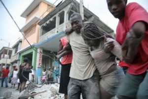 A Haitian woman is helped after being trapped in rubble in Port-au-Prince. Thousands are feared to have been killed in a massive earthquake in Haiti, President Rene Preval told a US daily Wednesday as he issued a plea for international help. (AFP/Daniel Morel)