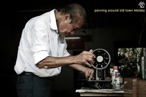 An elderly craftman repairing a sewing maching