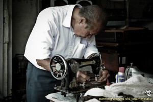 the elderly craft-man checking on a sewing maching