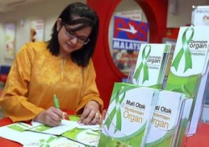 Detailed information: Yusasnita Mohd Yusof, 22, reading details of the organ donation form at Pos Malaysia in Jalan Telawi, Bangsar, Kuala Lumpur Friday.