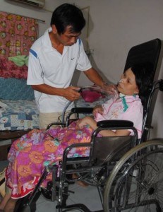 two months ago, Wang Yue-Fang collapsed and lying in coma; husband, Xue Shun-An doing mucus suction for Wang everyday (photo from Sin Chew Daily)