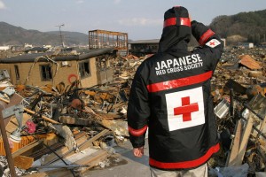 One week after the earthquake struck and tsunami surged through, a Japanese Red Cross volunteer surveys the damage to Otsuchi in Iwate prefecture. (Photograph: Japanese Red Cross Society)