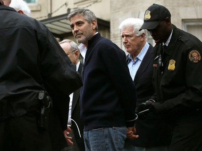 Clooney has handcuffs attached by a security official after being arrested outside the Embassy of Sudan today. (photo: Getty Images/Win McNamee)