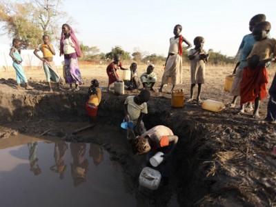 Sudanese from the war-torn Blue Nile state collect muddy water, in order to avoid the 12-hour queue at a water pump, in South Sudan's Doro refugee camp in December. More than 80,000 Sudanese have sought refuge in South Sudan from clashes between government forces and insurgents on the northern side of the poorly-marked and tense border, according to the United Nations. (photo: REUTERS/Hereward Holland)